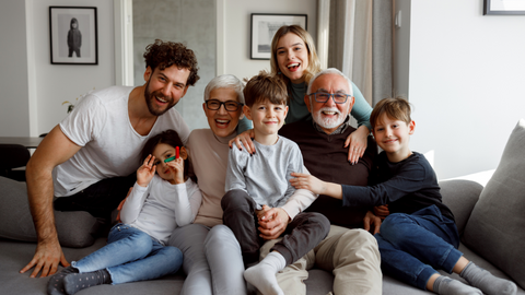 Image of family smiling and posing for a photo in a living room